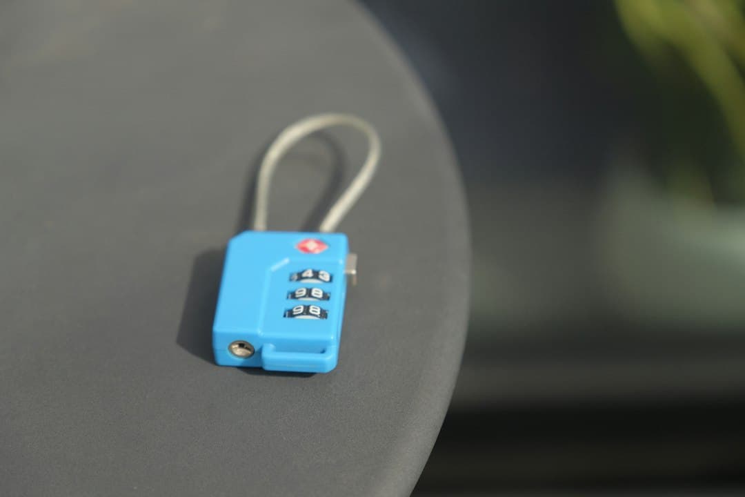 A small blue combination lock rests on a surface — Photo by Henry Williams on Unsplash
