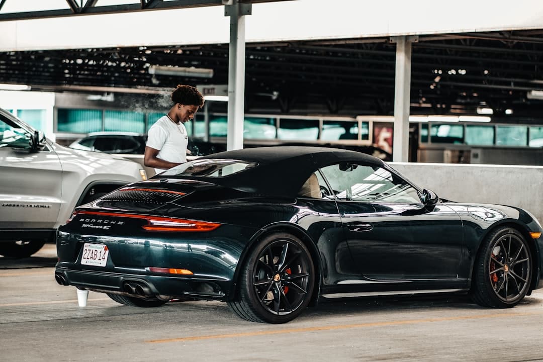 a person standing next to a black car — Photo by Ansspvt Titan on Unsplash