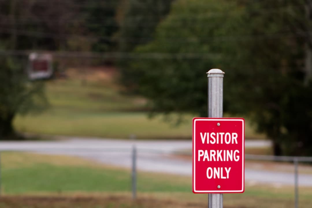 A red parking only sign sitting on the side of a road — Photo by Jacob McGowin on Unsplash