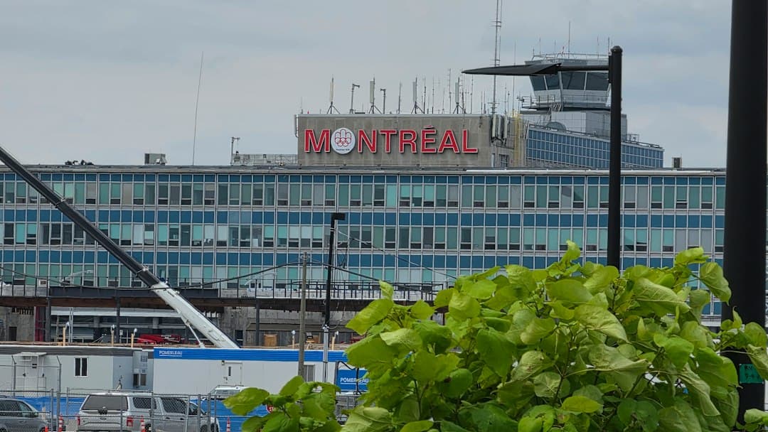 The Montreal sign on a large blue office building with a control tower — Photo by Medad Media on Unsplash