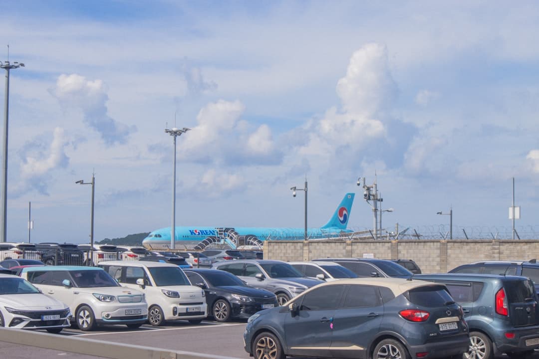 Cars parked with airplane in background — Photo by yeojin yun on Unsplash