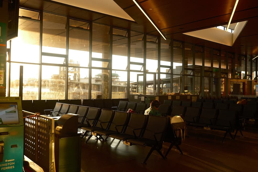 Airport waiting area with rows of seats and large windows. — Photo by Luke Robinson on Unsplash