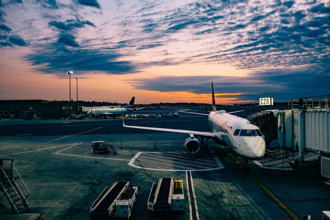 white airplane near trailers during sunset — Photo by Ashim D’Silva on Unsplash