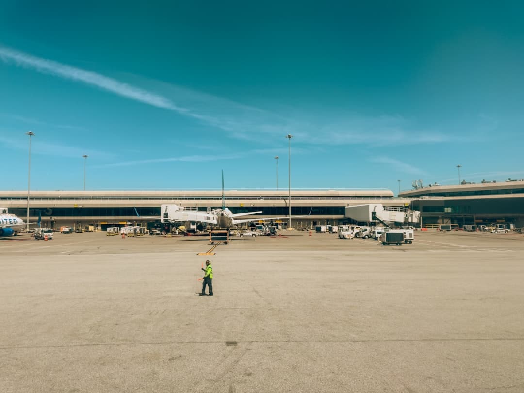 An airport apron with a plane and workers. — Photo by Fabio Sasso on Unsplash