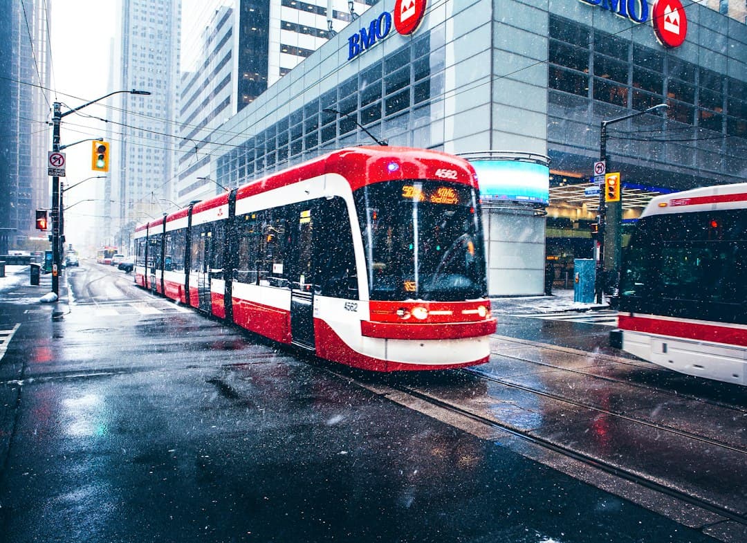 white and red bus on road near buildings during daytime — Photo by Marcin Skalij on Unsplash