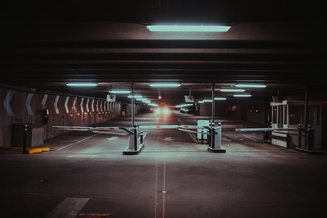 an empty parking garage with lights on the ceiling — Photo by Colin Lloyd on Unsplash